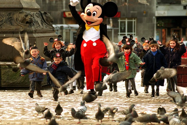 Mickey Mouse flew in to Leeds from Florida's Walt Disney World. He is pictured dancing through City Square with children from St Joseph's R.C. Primary School in Hunslet.