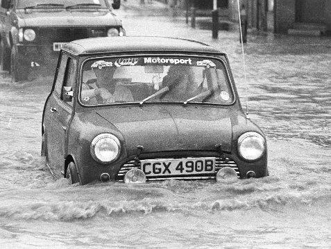 It's not just the past couple of years that the district has had to deal with flooding. Here a car tries to get across a submerged street in 1983.