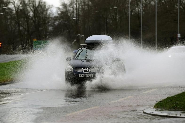 A car driving through flood water on Otley Road.