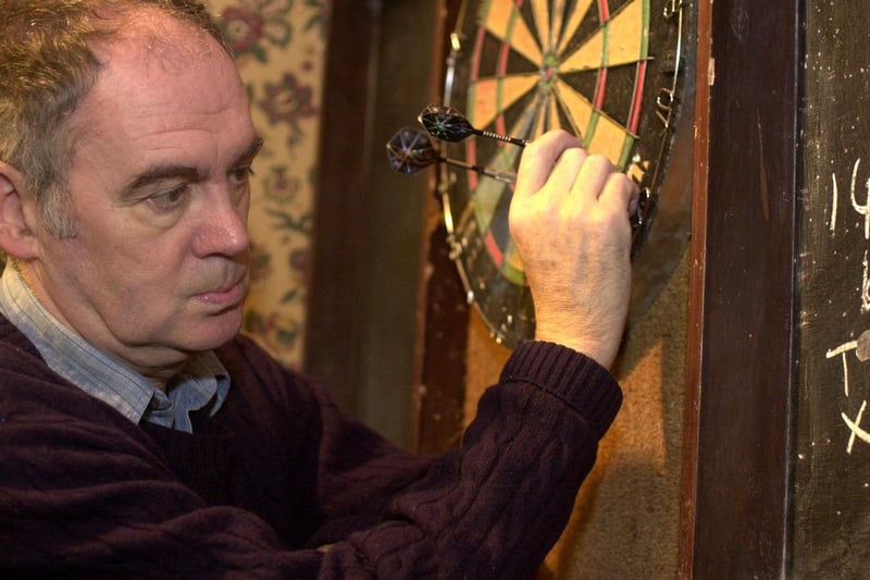 December 2000 and Sky Sports commentator Sid Waddell warms up for the darts season by practising at his local The White Cross in Pudsey.