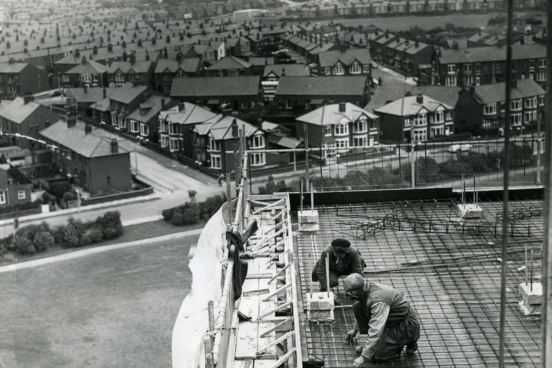 Men working on the high rise flats at Queenstown, Layton,  in 1963. Cumbrian Avenue joins Mather Street which runs left to right across the centre . The spire of Layton Hill Convent School (now St Mary's High school) can be seen in the distance to the left. The open ground of Kingscote playing fields can be seen top right. The flats are now demolished.