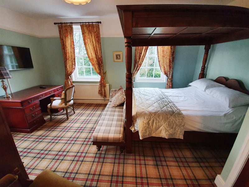 A huge four poster bed is the focus in this bedroom.