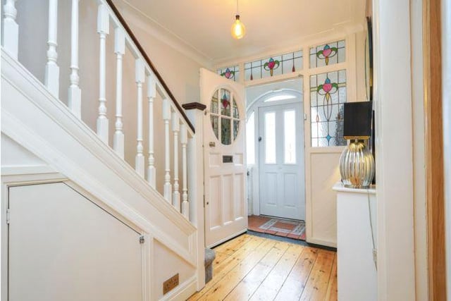 Enter into the entrance porch with its traditional stained glass door.