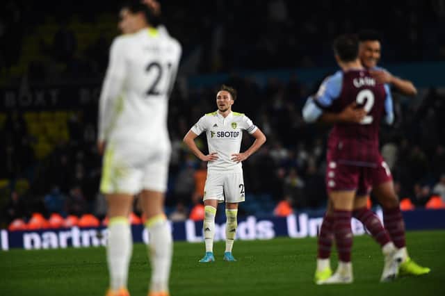 JOY AND PAIN: Aston Villa's players celebrate after the full-time whistle at Elland Road as Leeds United captain Luke Ayling, back, and Pascal Struijk, front, reflect on a hugely disappointing defeat. Picture by Jonathan Gawthorpe.