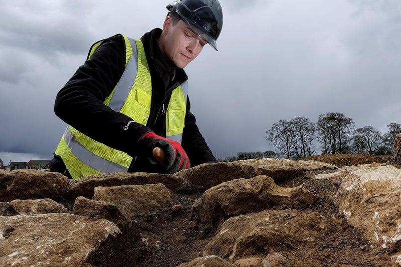 Trainee Field Archaeologist Corey Greening inspects Roman stonework.