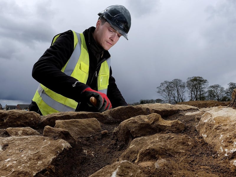Trainee Field Archaeologist Corey Greening inspects Roman stonework.