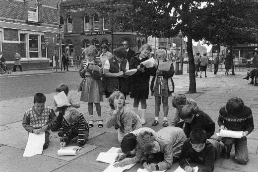 A press photograph of children from Castleford's Half Acres Middle School studying architectural styles in the town centre