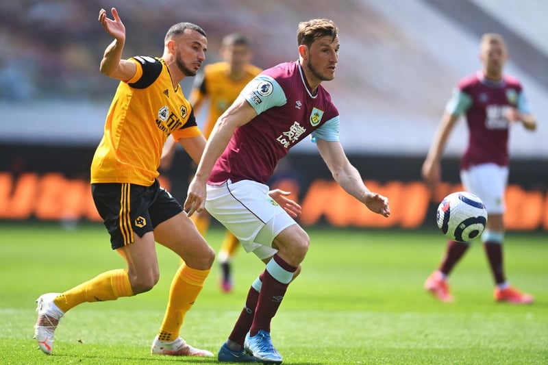 Chris Wood of Burnley is closed down by Romain Saiss of Wolverhampton Wanderers during the Premier League match between Wolverhampton Wanderers and Burnley at Molineux on April 25, 2021 in Wolverhampton, England.