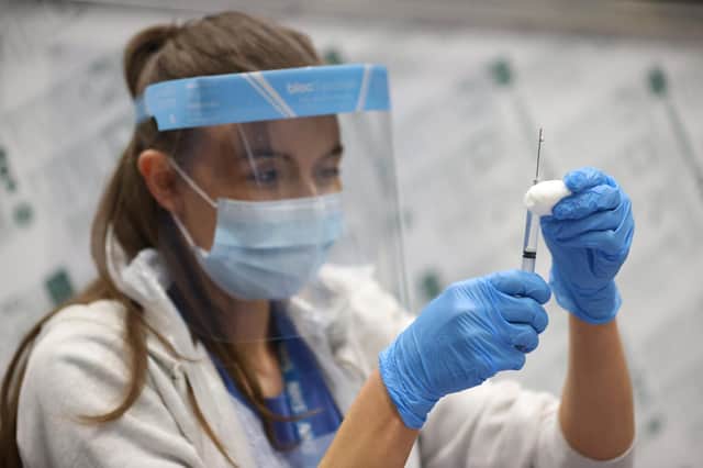 A vaccinator prepares vaccines at a COVID-19 booster vaccination centre