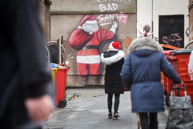 Shoppers in front of some festive graffiti in the town
