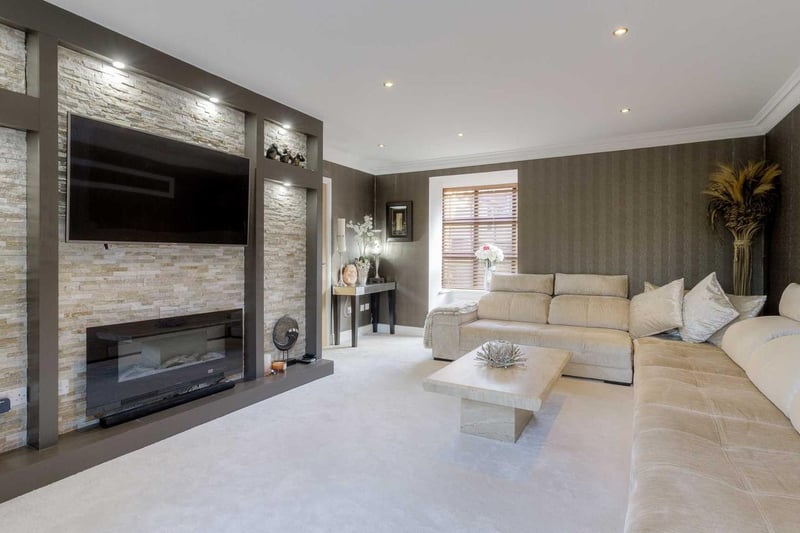 This spacious family room has a built-in fireplace and gigantic sofa perfect for lazy Sundays in.