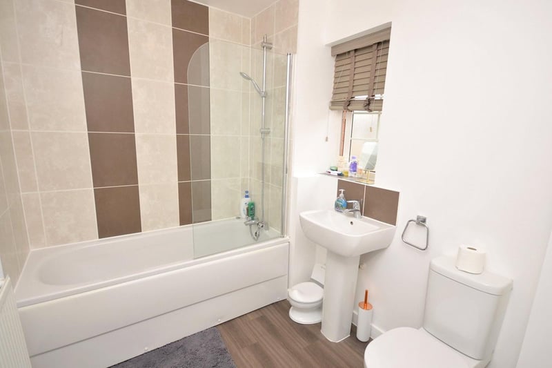 Family bathroom offers a modern white suite with w/c, wash hand basin and panel bath with separate shower controls over.