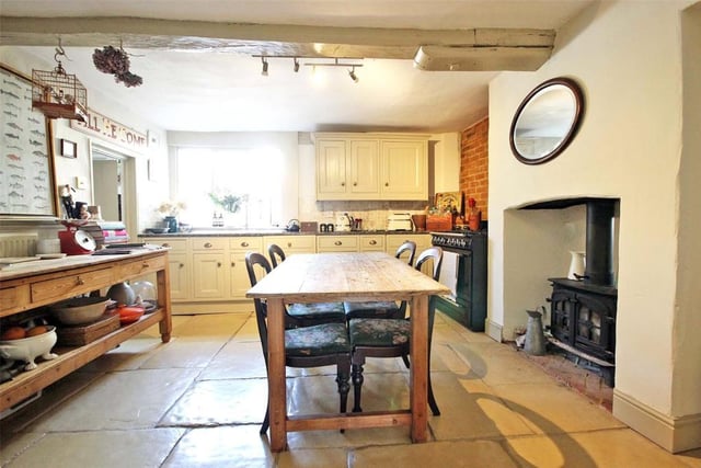 The bespoke country-style kitchen offers space for a table and features a two-sided multi-fuel burner which connects the kitchen and dining room