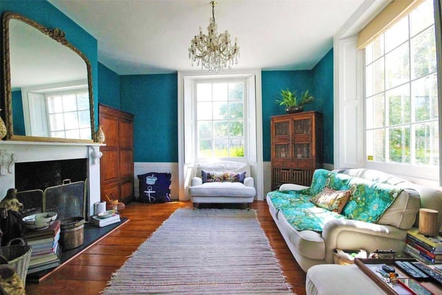 The impressive dual aspect sitting room boasts exposed floorboards and open fireplace. Look at those colours