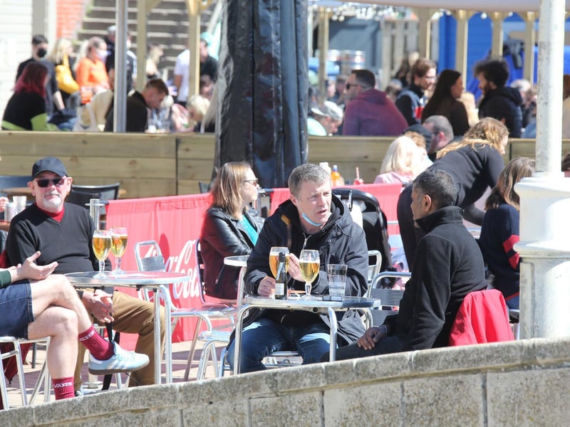 People enjoying drinks by the beach in the sun. Photo: Eddie Mitchell