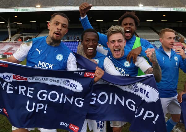 Posh player, from left, Jonson Clarke-Harris, Siriki Dembele, Sammie Szmodics, Ricky-Jade Jones and Louis Reed celebrate promotion.