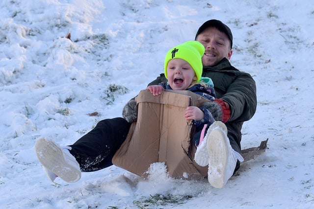 Thea McElhinney, aged 4, enjoys a slide in the snow, with dad Caomhan, at the Creggan Burn on Saturday morning last. Photo: George Sweeney / Derry Journal.  DER2104GS –  018