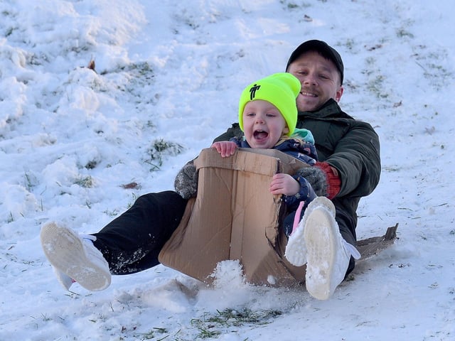 Thea McElhinney, aged 4, enjoys a slide in the snow, with dad Caomhan, at the Creggan Burn on Saturday morning last. Photo: George Sweeney / Derry Journal.  DER2104GS –  018