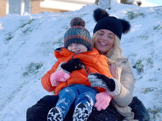 Five year old Austin enjoying a slide in the snow, with Shannon, at the Creggan Burn on Saturday morning last. Photo: George Sweeney / Derry Journal.  DER2104GS – 019