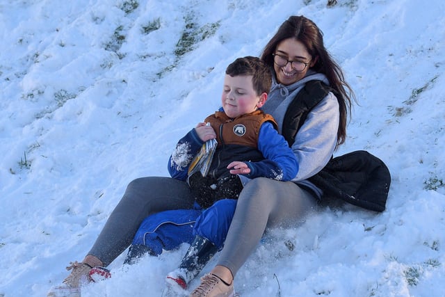 Jacob Simpson, aged 6, and Jayne McSherry slide in the snow at the Creggan Burn on Saturday morning last. Photo: George Sweeney / Derry Journal.  DER2104GS – 020