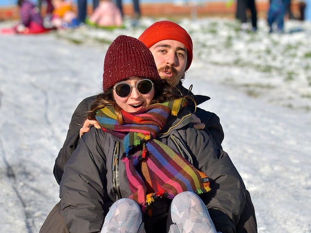 A happy couple enjoy a slide in the snow covered Brooke Park on Saturday afternoon last. Photo: George Sweeney / Derry Journal. DER2104GS – 010