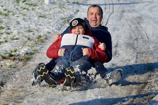 Mayor of Derry and Strabane Colr. Brian Tierney and his son Cian enjoy a slide in a snow covered Brooke Park on Saturday afternoon last. Photo: George Sweeney / Derry Journal.  DER2104GS – 024