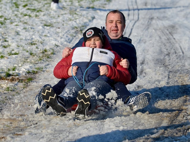 Mayor of Derry and Strabane Colr. Brian Tierney and his son Cian enjoy a slide in a snow covered Brooke Park on Saturday afternoon last. Photo: George Sweeney / Derry Journal.  DER2104GS – 024