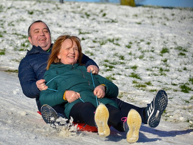 Mayor of Derry and Strabane Colr. Brian Tierney and his mum Mary enjoy a slide in a snow covered Brooke Park on Saturday afternoon last. Photo: George Sweeney / Derry Journal.  DER2104GS – 014