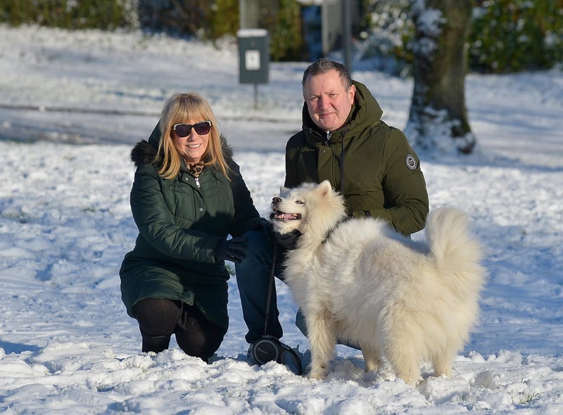 Joan and Terry Casey pictured with their dog Sasha in a snow covered Brooke Park on Saturday afternoon last. Photo: George Sweeney / Derry Journal.  DER2104GS – 031