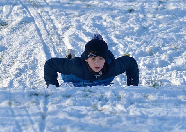Sliding in a snow covered Brooke Park on Saturday afternoon last. Photo: George Sweeney / Derry Journal.  DER2104GS – 032
