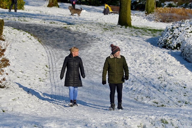 A couple enjoy a walk in a snow covered Brooke Park on Saturday afternoon last. Photo: George Sweeney / Derry Journal.  DER2104GS – 033