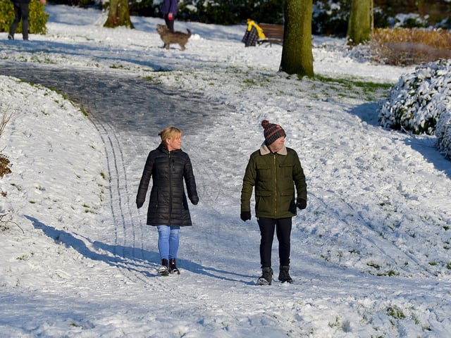 A couple enjoy a walk in a snow covered Brooke Park on Saturday afternoon last. Photo: George Sweeney / Derry Journal. DER2104GS – 033