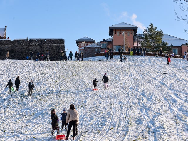 Families enjoy the snow on the banking overlooking the Bogside on Saturday afternoon last. Photo: George Sweeney / Derry Journal. DER2104GS – 035