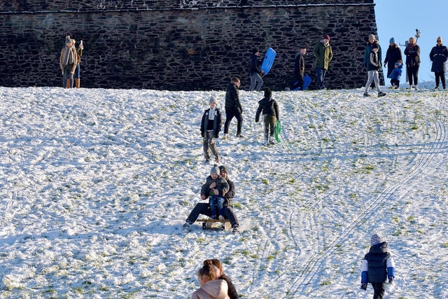 Families have fun in the snow, on the banking overlooking the Bogside, on Saturday afternoon last. Photo: George Sweeney / Derry Journal.  DER2104GS – 036