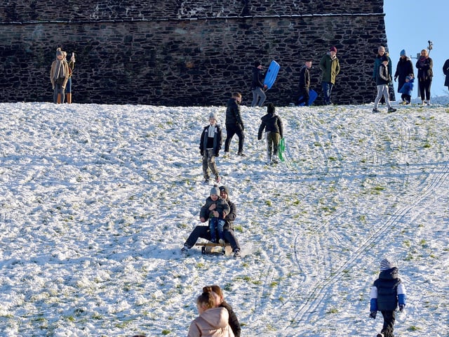 Families have fun in the snow, on the banking overlooking the Bogside, on Saturday afternoon last. Photo: George Sweeney / Derry Journal. DER2104GS – 036