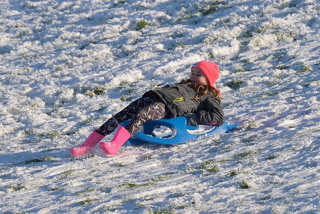 Enjoying sliding the snow, on the banking overlooking the Bogside, on Saturday afternoon last. Photo: George Sweeney / Derry Journal.  DER2104GS – 037