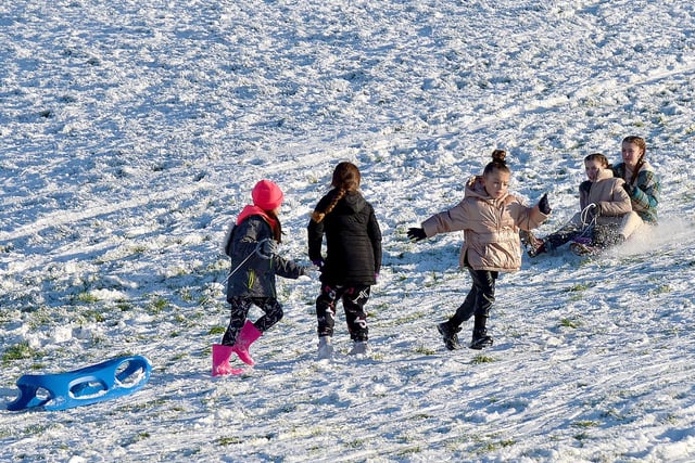 Children have fun on the snow covered banking overlooking the Bogside, on Saturday afternoon last. Photo: George Sweeney / Derry Journal.  DER2104GS – 039