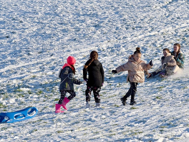 Children have fun on the snow covered banking overlooking the Bogside, on Saturday afternoon last. Photo: George Sweeney / Derry Journal. DER2104GS – 039