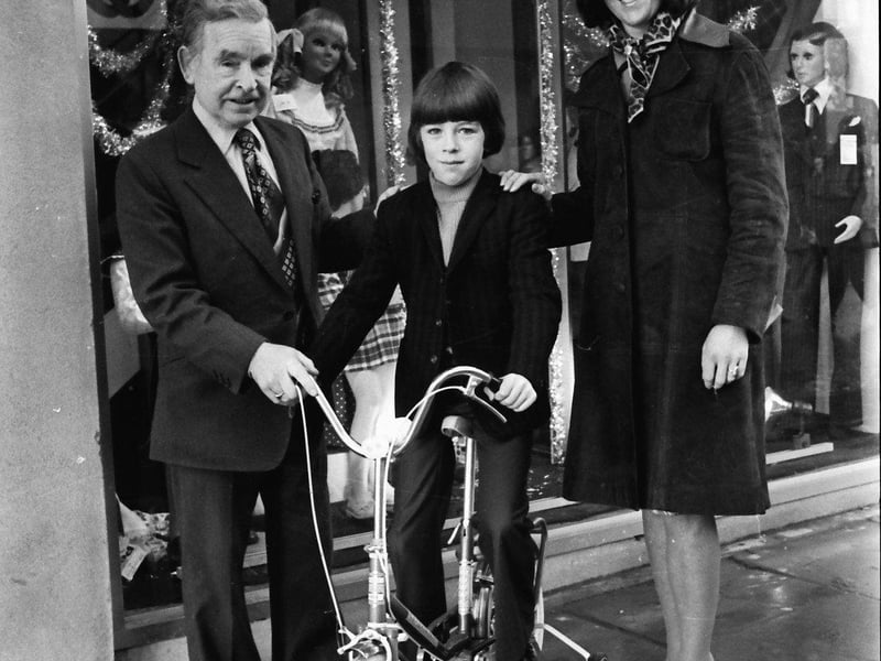 Winner of the bicycle in Messrs Hasson's Christmas shopping prize draw, Bernadette Quigley, Ballyarnett House, donated the prize to St Joseph's Home, Termonbacca. Master Anthony Cavanagh is seen receiving the cycle on behalf of St Joseph's, from Mr Laurence Hasson, managing director, with, on right, Miss Quigley.