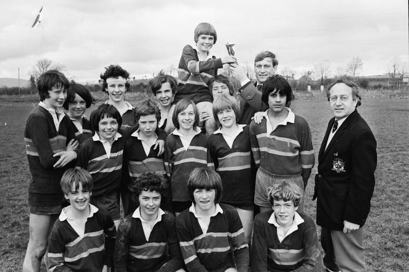 Willie John McBride, former captain of the Irish and Lions rugby teams, presenting the trophy to Keith Hegarty, captain of the Foyle College team which won the City of Derry Rugby Club's under-13 competition for secondary schools held at the club grounds at Buncrana Road. Included, on right, is president of the club, Ted Maxwell.