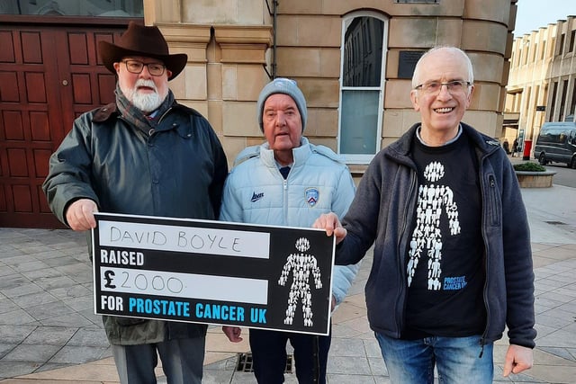 Caring Caretaker Davy Boyle presents Michael Currid from Prostate Cancer with a cheque for £2,000. Also pictured is Davy's friend and supporter Maurice Greer