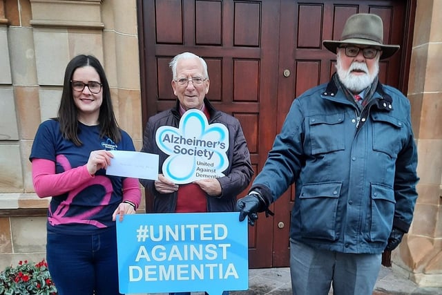 Caring Caretaker Davy Boyle presents Aoife McMaster and Edward McAuley of the Alzheimer's Society with a cheque for  £2,000