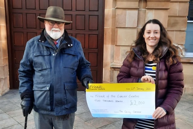 Caring Caretaker Davy Boyle presents Ay Reynolds from Friends of the Cancer Centre with a cheque for £2,000