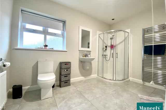 The family bathroom with modern white suite and tiled floor.