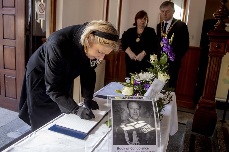 The Lord Lieutenant of County Londonderry Mrs Alison Millar writes her message of condolence as the Mayor of Causeway Coast and Glens Borough Council Alderman Mark Fielding and Mayoress Phyllis Fielding look on