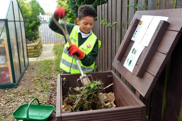 Broadway Junior School pupil Wez Cole, nine, gets to work at the garden compost bin.