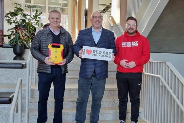(from left) Craig Hanson, Coun Graeme Miller and Sergio Petrucci with one of The Red Sky Foundation's defibriallators