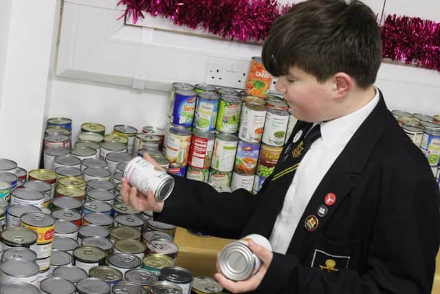 Sam Nightingale, 14, helping to sort through the thousands of tins.
