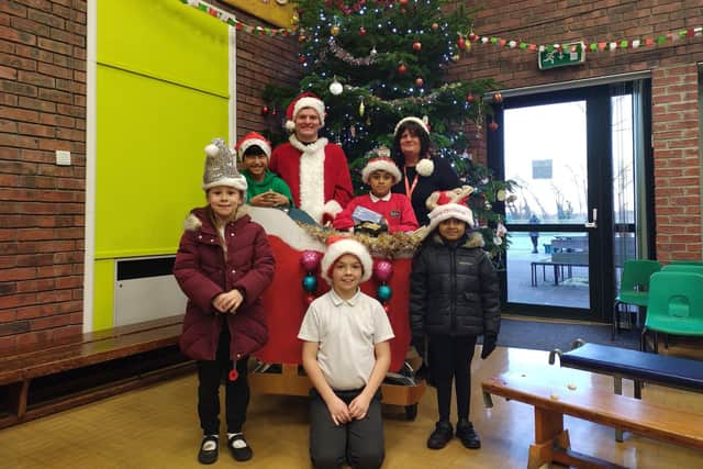Teaching assistant Simon Spoors and headteacher Claire McKinney alongside pupils Alec Clenante, Yaseem Ahmed, Liana Leighton, Jamie Robson and Siabah Ahmed and their sleigh full of donations for Sunderland Food Bank.