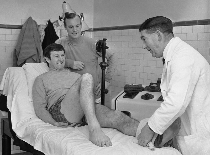 Gordon Harris looks on (right) while George Mulhall receives treatment for an ankle injury from pysiotherapist John Watters at SAFC in 1968.